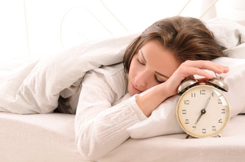 sleeping woman with an alarm clock