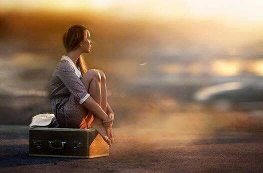 Woman sitting on a suitcase