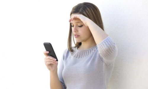 携帯を見ながら考える女性