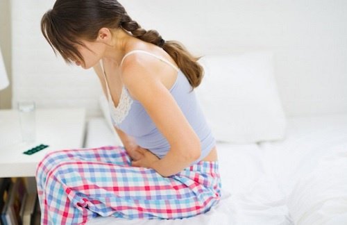 お腹に手をやる女性の姿
