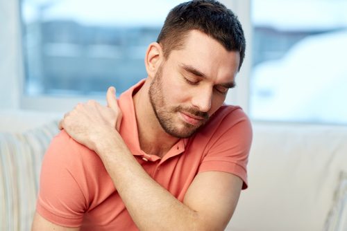肩の痛みに耐える男性