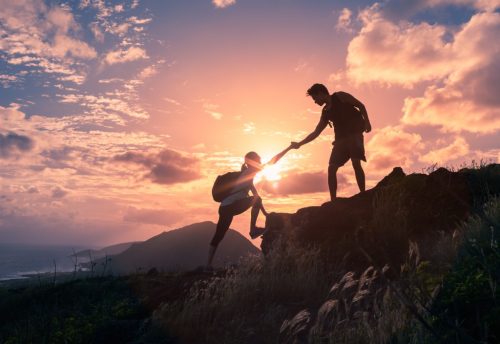 夕日を背景に山登りする人たち