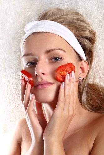 トマトを顔にあてる女性