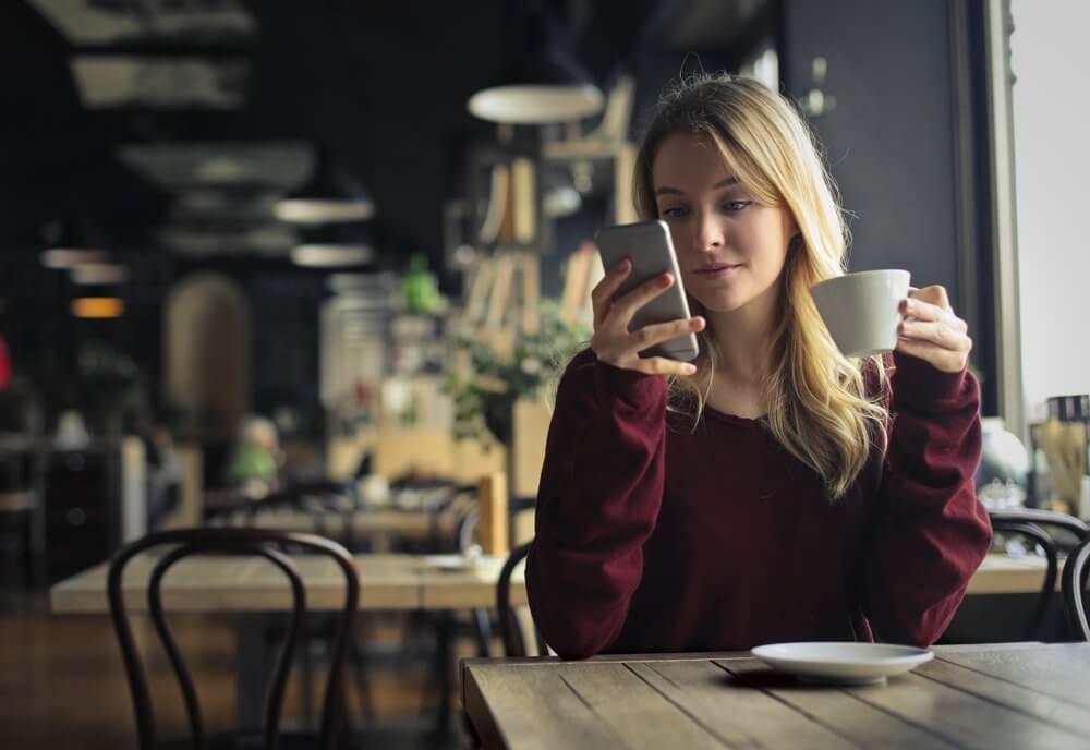 カフェで携帯を見る女性