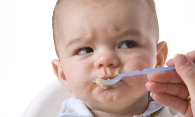 離乳食を食べて顔をしかめる赤ちゃん