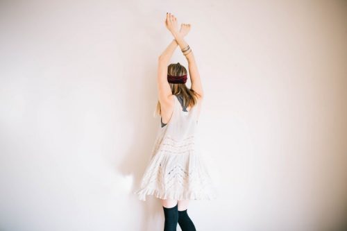 手首を交差させた後ろ姿の女性