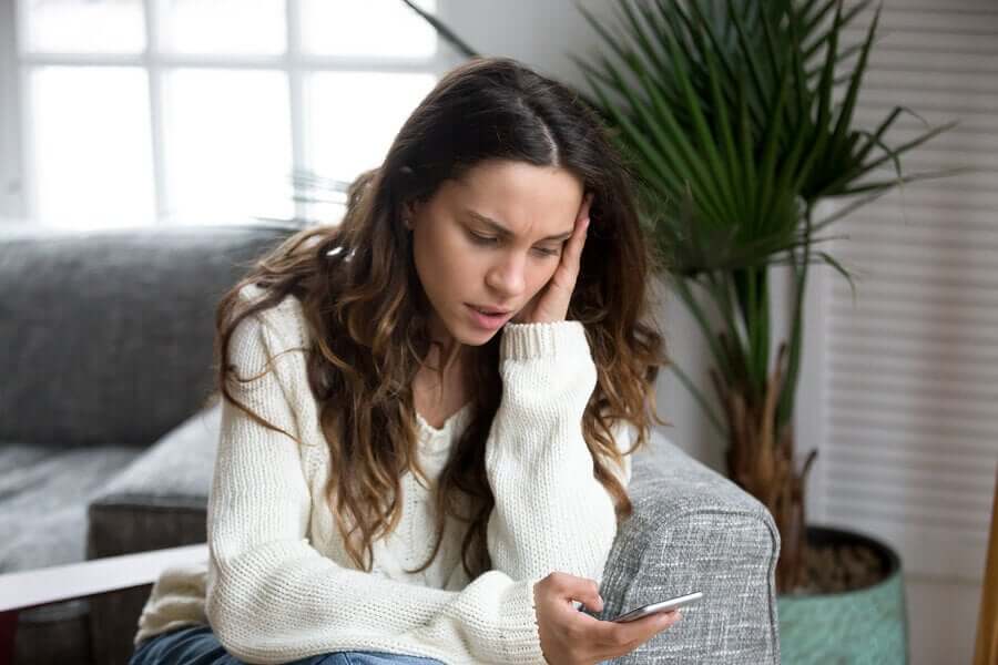 携帯を手に不安がる女性