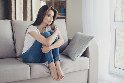 ソファで膝を抱える女性