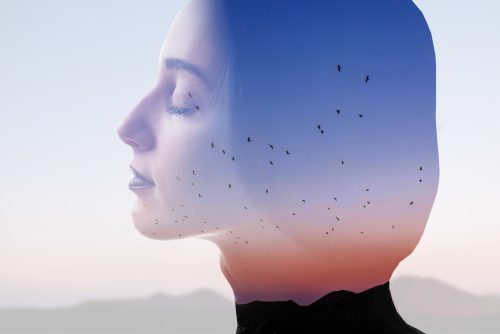 空を背景に目を閉じる女性