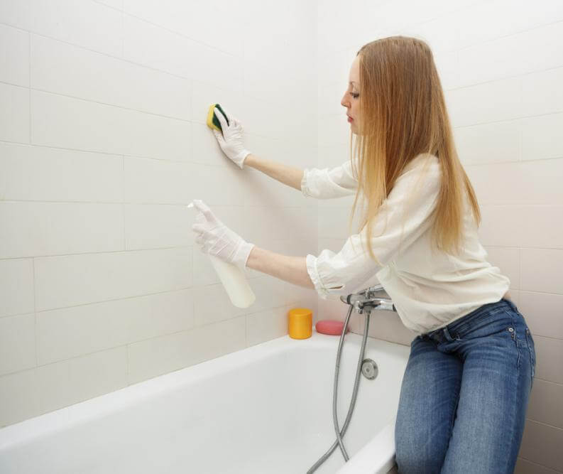 浴室の壁を掃除する女性