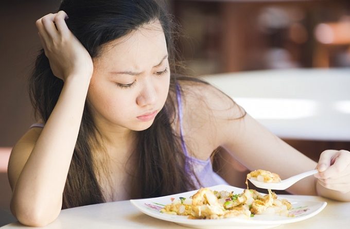 料理を前に不機嫌な女性