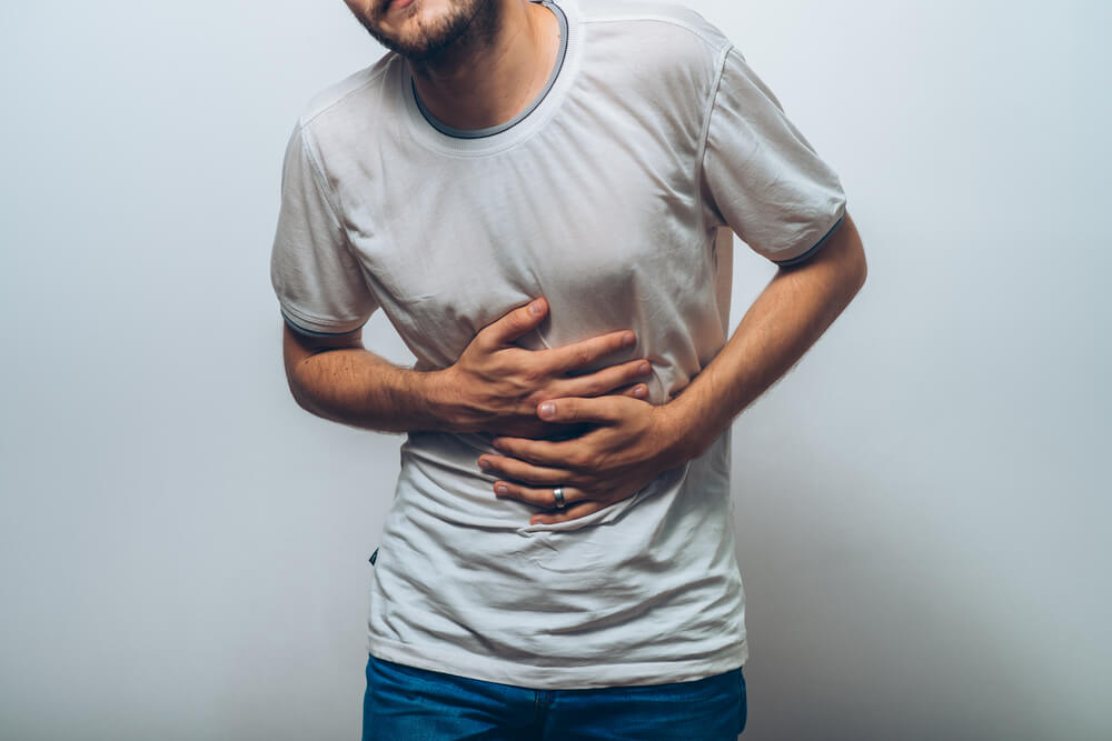 腹部を抑える男性