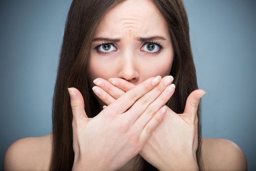 口を押さえる女性