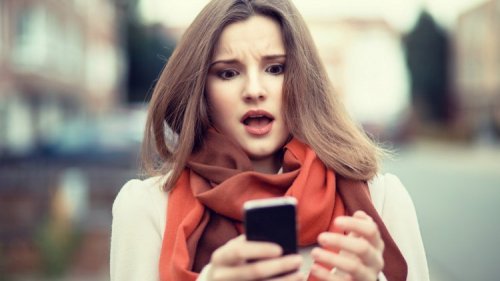 スマホを見て驚く女性