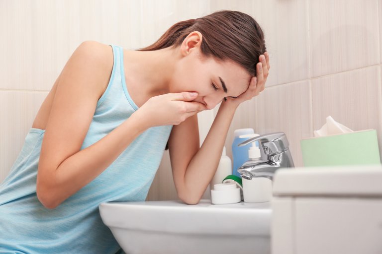 吐き気でビデにかがみこむ女性