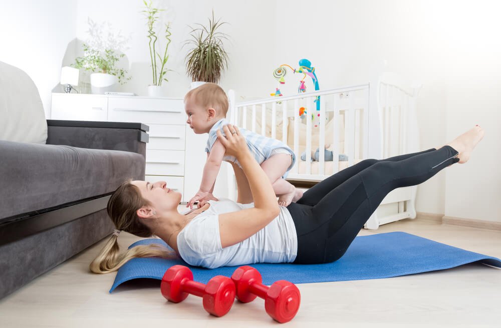 赤ちゃんと体操する女性