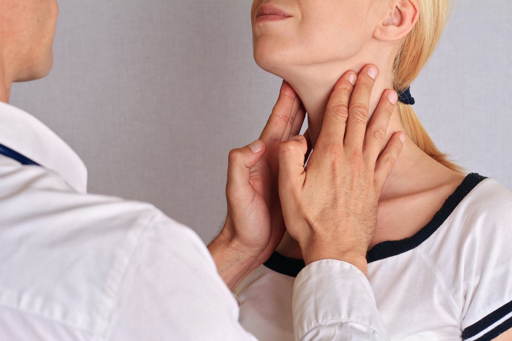 甲状腺の触診を受ける女性