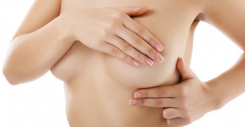 乳房を手で抑える