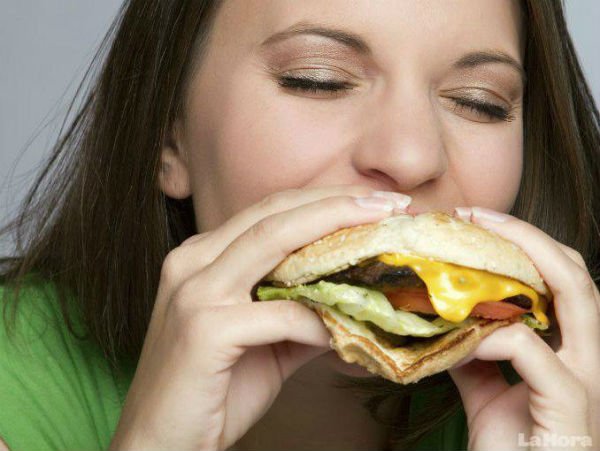 ハンバーガーをほおばる女性