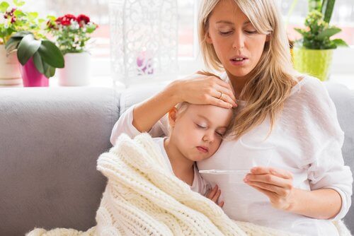 子どもの熱を測る母親