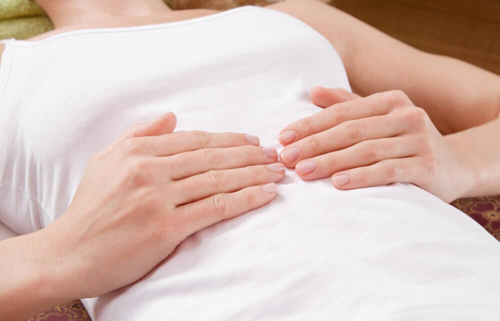 お腹を押さえる女性