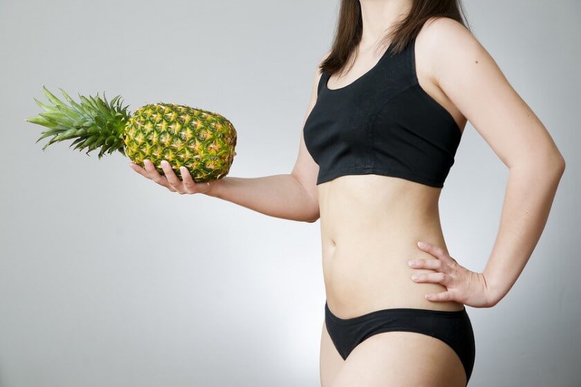 パイナップルを片手に持つ女性