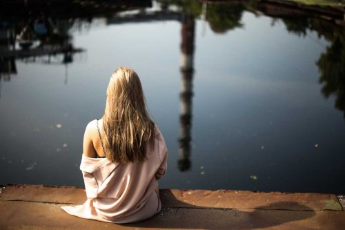 水辺に座る女性　孤独を感じる理由