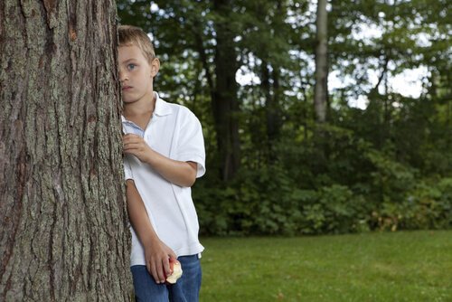 木の後ろに立つ子供