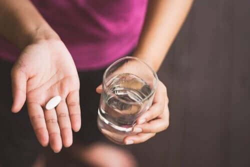 血圧を下げる薬：バルサルタンの用途と副作用　薬を飲む女性