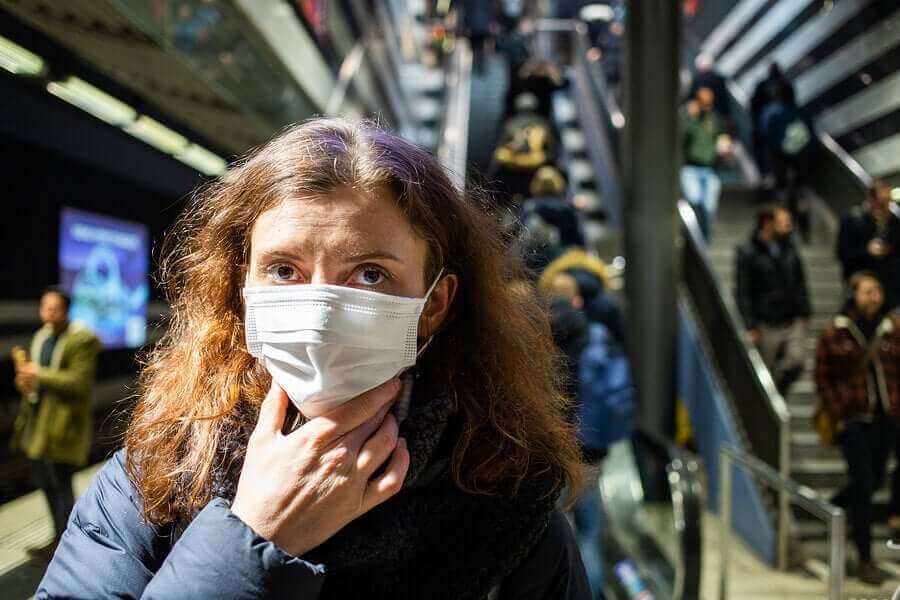COVID-19のパンデミック：顔に触れないためのヒント　マスクをつける女性