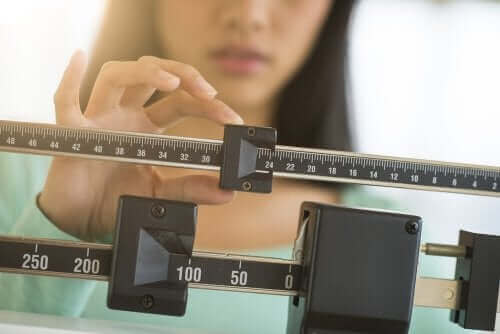 キャロブパウダー：6つの特性と利点　体重を測る女性
