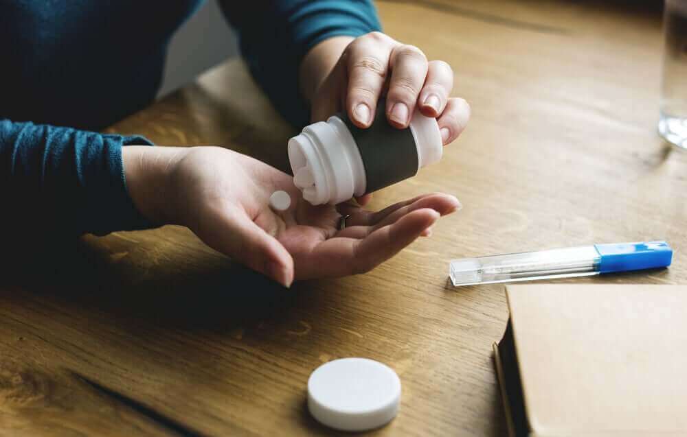 新型コロナウイルスとイブプロフェンは危険な組み合わせですか? 錠剤を飲む患者