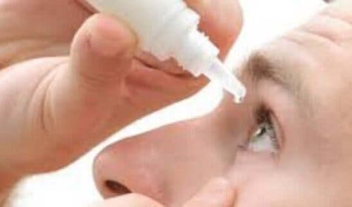 目薬を注す男性