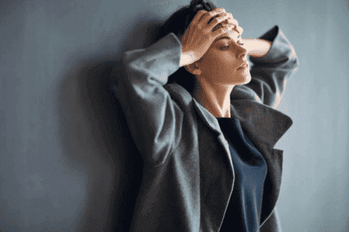 壁にもたれる女性