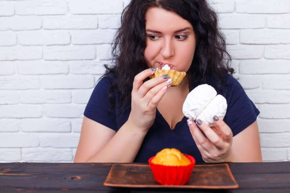 過食の因果関係：原因と健康への悪影響について　焼き菓子を過食する女性
