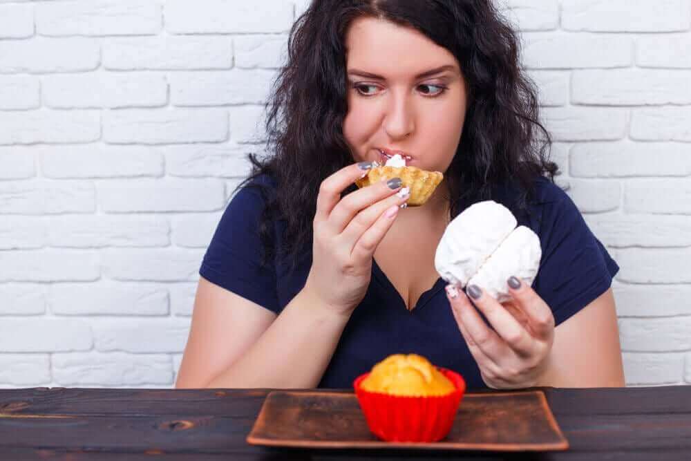 過食の因果関係:原因と健康への悪影響について 焼き菓子を過食する女性