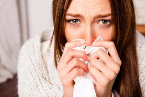 冬になるとインフルエンザの流行が広がる理由　くしゃみが出ている女性